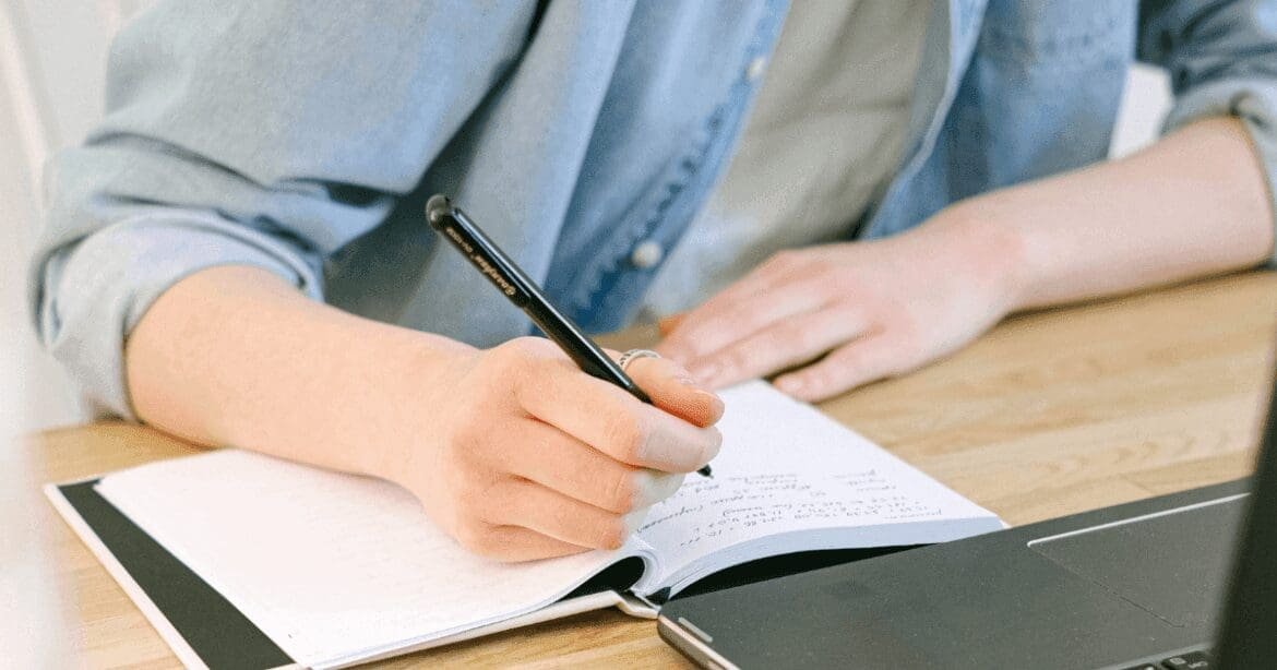 Woman typing on a laptop, sipping coffee, immersed in her blogging tasks