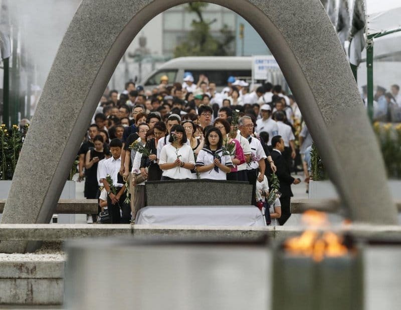 People pray for the atomic bomb victims in front of the cenotaph at the Hiroshima Peace Memorial Park in Hiroshima, western Japan, during a ceremony to mark the 74th anniversary of the bombing Tuesday, Aug. 6, 2019. Photo: Kyodo News via Japan Watch