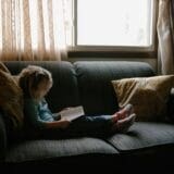 A young kid reading her older versions journal, as a letter of reflection for her