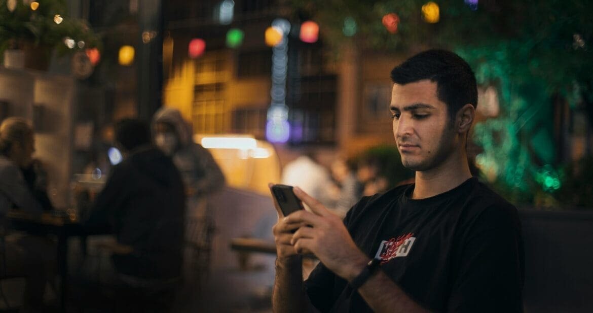 Adult hesitating before texting an old friend, feeling the weight of loneliness