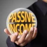 An image of a person holding a passive income orb for an article about passive income myths.