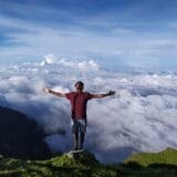 Person standing alone on a mountaintop, representing forgiveness and emotional healing through grief.