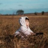 Thoughtful child sitting alone in nature representing the inner child