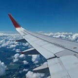 Airplane window seat view flying to hidden gem travel destinations