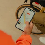 Runner using the Strava app for fitness tracking on a scenic trail