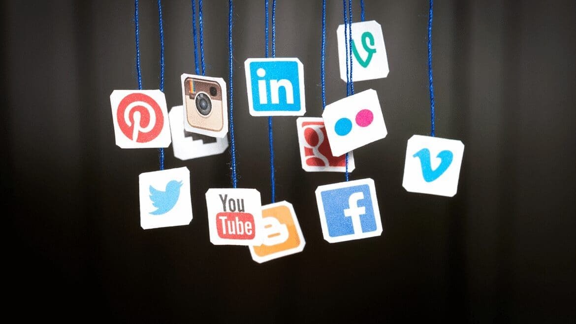 Illustration of hanging pictures displaying various social media app icons against a neutral background.