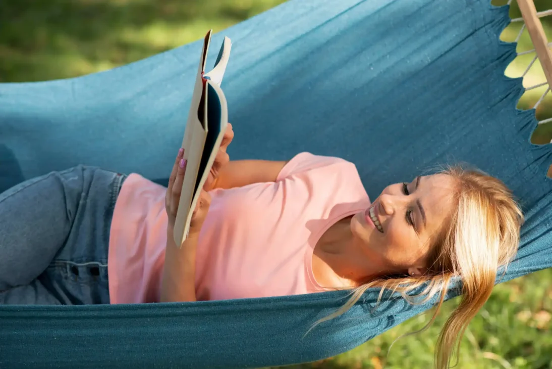 reading outdoors in hammock with herbal tea for mental rest and natural energy recharge