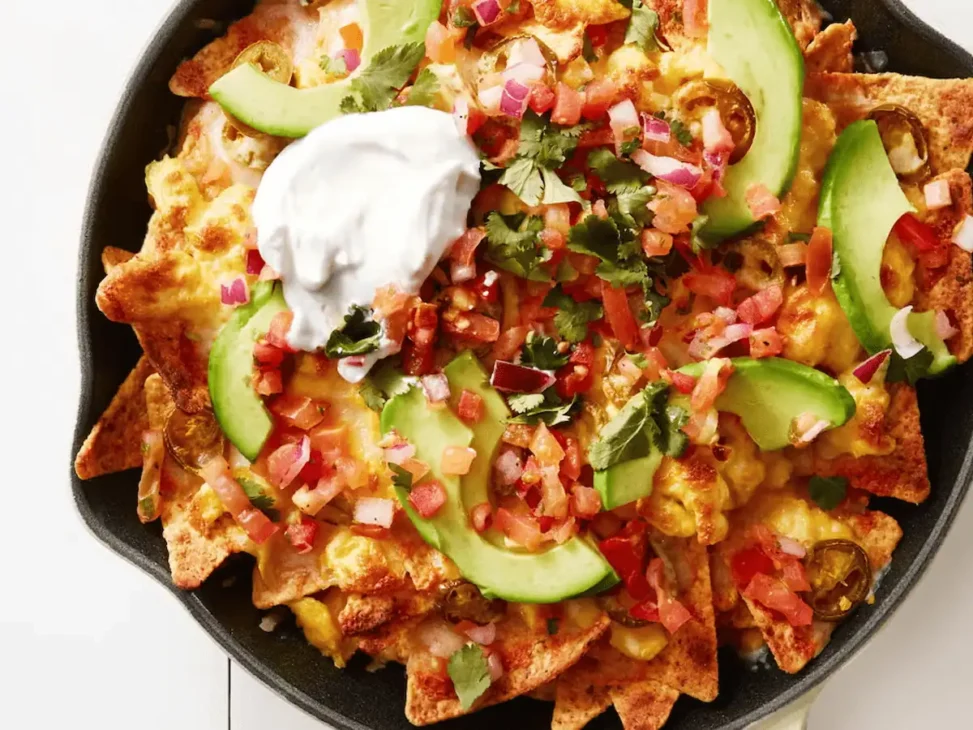 Mexican chilaquiles with tortilla chips, salsa, cheese, and a fried egg on top.