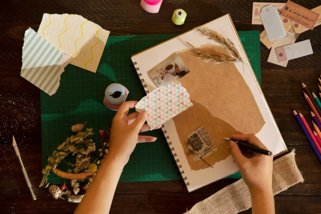 Scrapbooking journal with ticket stubs, flowers, and postcards