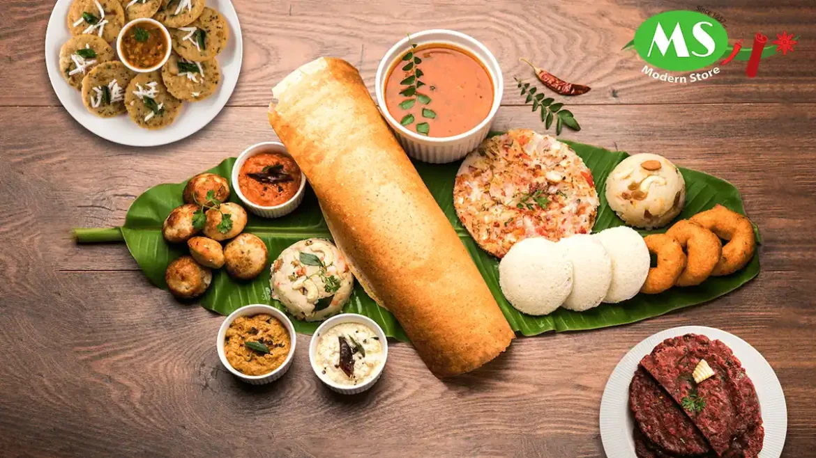 Indian breakfast with dosa, stuffed paratha, idli, chutneys, and sambar.