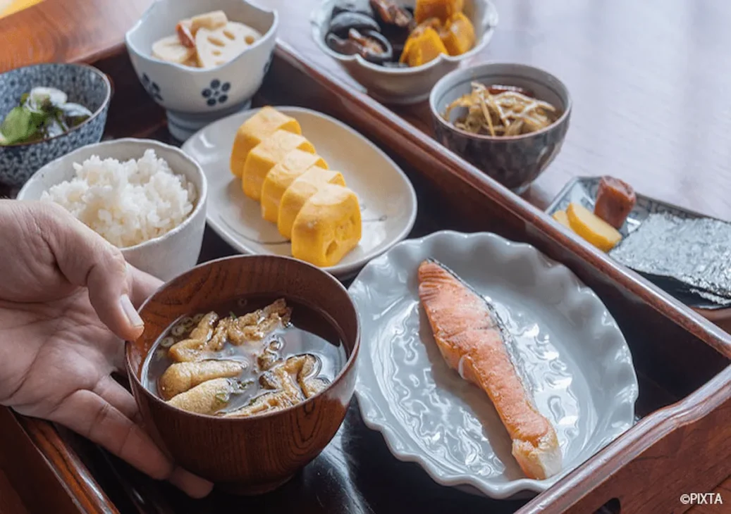 Japanese breakfast with steamed rice, miso soup, grilled fish, pickles, and nori.