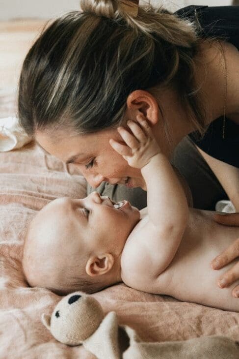Happy mother holding her newborn baby close, smiling and bonding, showing the joy and connection of early motherhood. Photo by Febe Vanermen, Pexels
