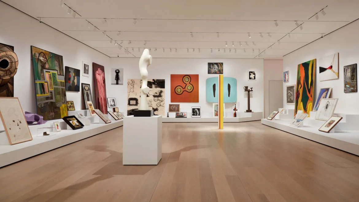 Cozy museum interior with a mix of large and small artworks displayed in warm lighting.
