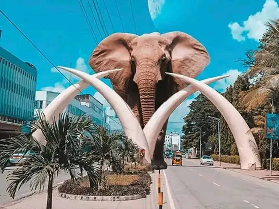 The famous Mombasa Tusks landmark:m four large, curving elephant tusks forming an arch over a central road, with a stylized elephant face superimposed in the background, a must-see on any Mombasa travel itinerary.