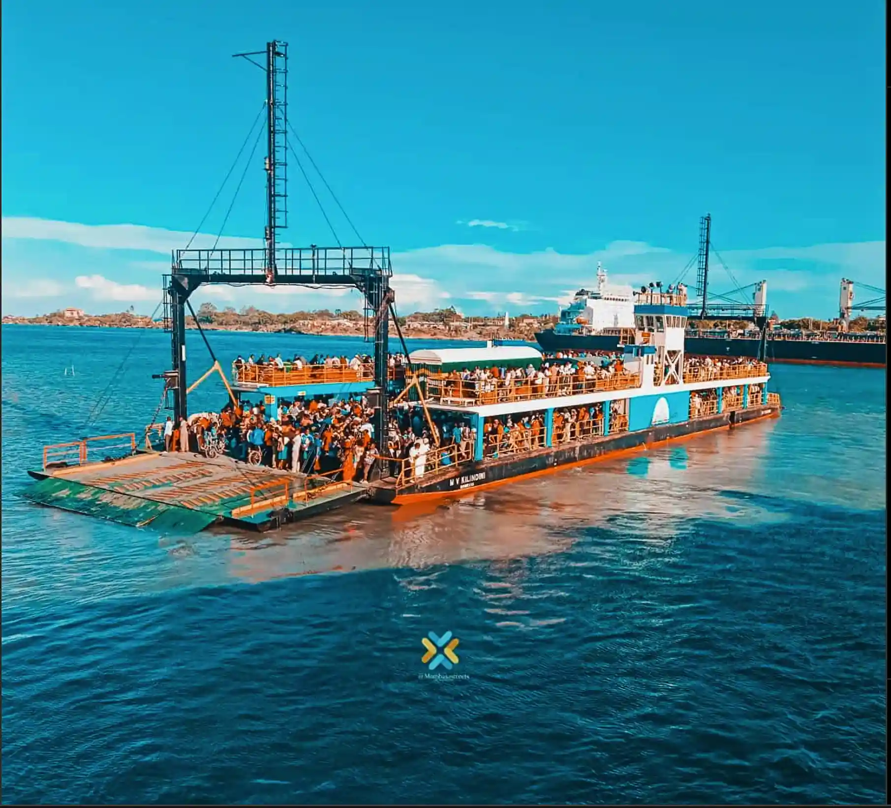 The iconic Likoni Ferry (MV Kilindini) packed with commuters and crossing the harbor, a mandatory part of experiencing Mombasa travel.