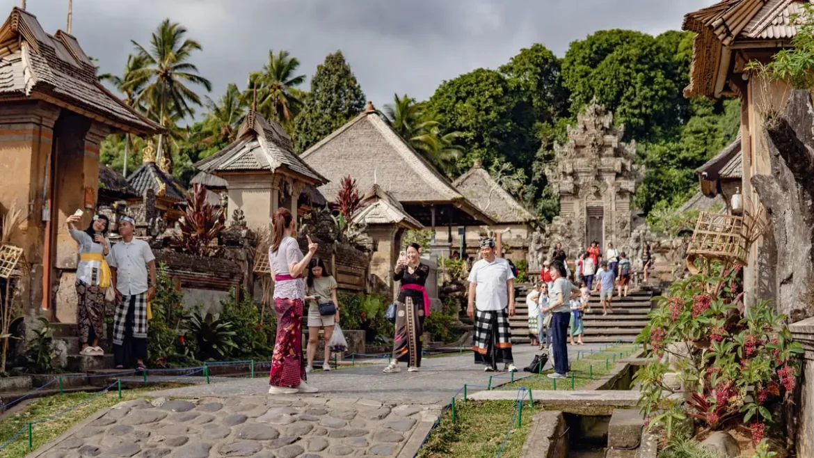 Local Balinese villagers chatting in a quiet rural lane surrounded by rice fields and traditional homes in Bali villages.