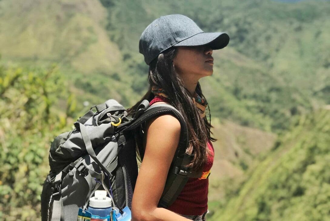 Solo traveler arriving at a tour meeting point, backpack on, checking a map while a small group of travelers waits in the background.