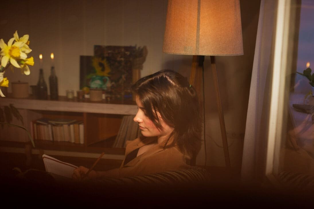 Introvert self-care routine showing a person unwinding with soft lighting, quiet space, and simple activities to decompress after people-heavy days