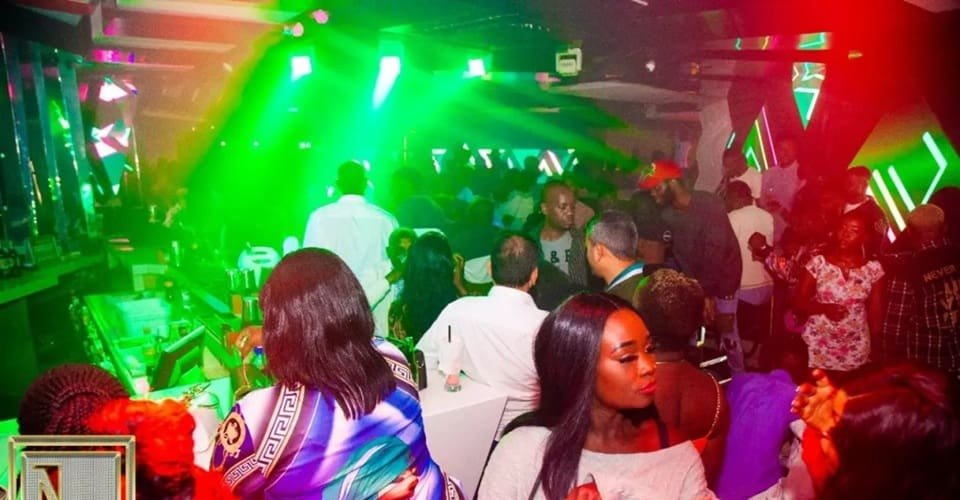 First-time visitors experiencing the vibrant and social atmosphere of Nairobi nightlife, engaging with locals and fellow travelers.