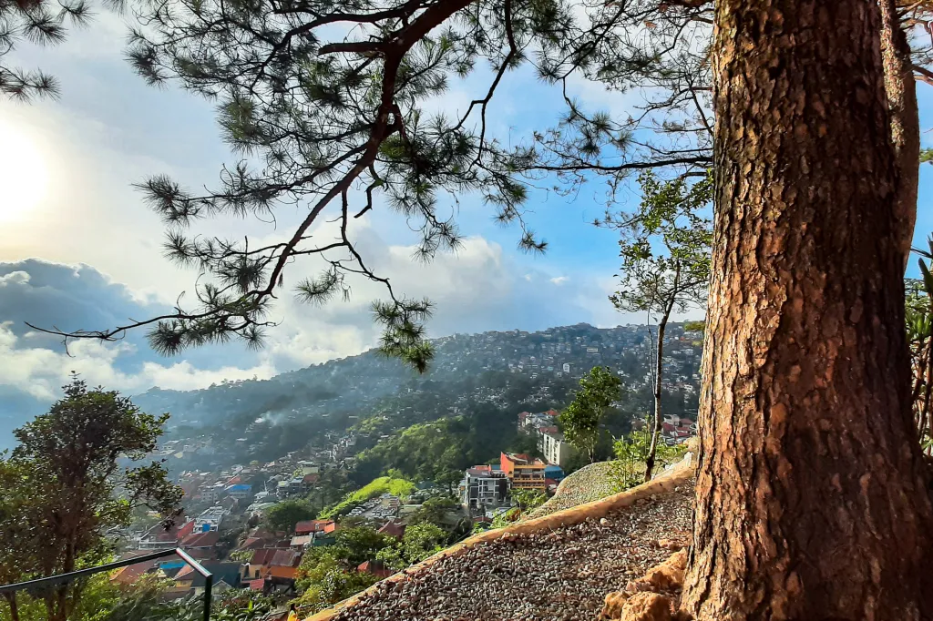 Overlooking view of Baguio City with rolling hills, pine trees, and layered mountain scenery