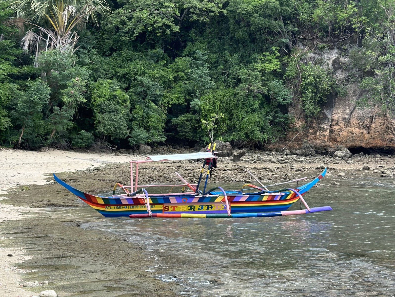 Kayak floating on calm, sunlit waters of Puerto Galera with gentle waves and reflections.