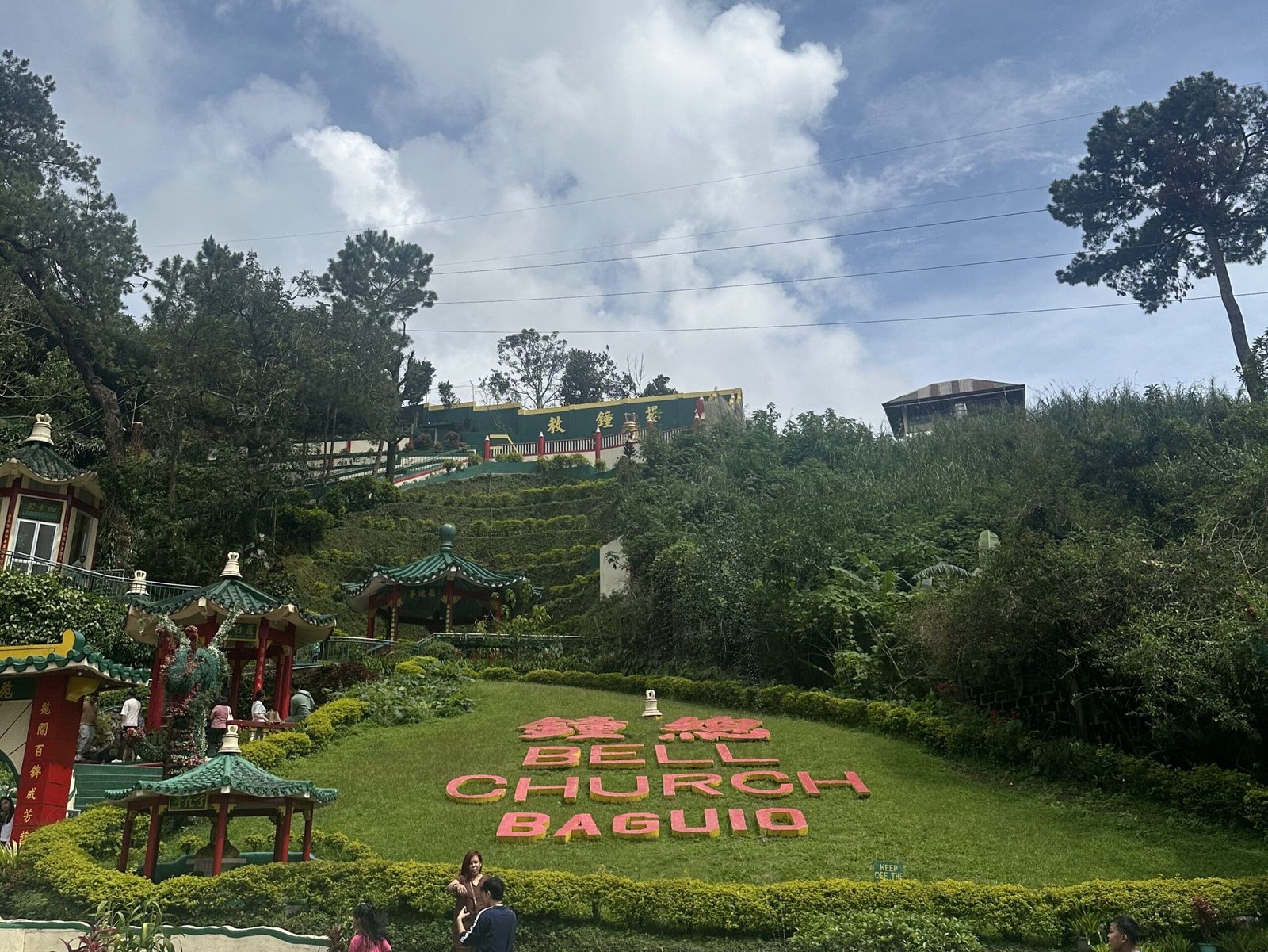Bell Church Taoist Temple in Baguio City featuring red pagodas, dragon details, and mountain backdrop