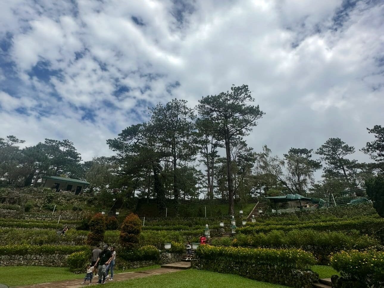 Bell Amphitheater at Camp John Hay surrounded by tall pine trees and walking paths in Baguio