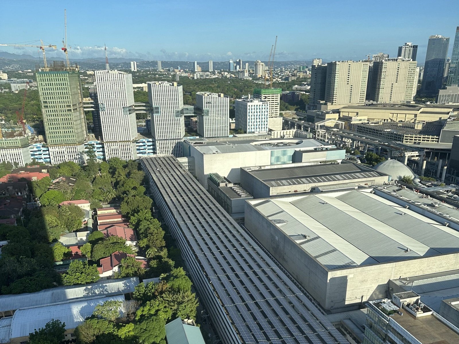View of Manila city skyline from hotel window, capturing bustling buildings and urban energy.