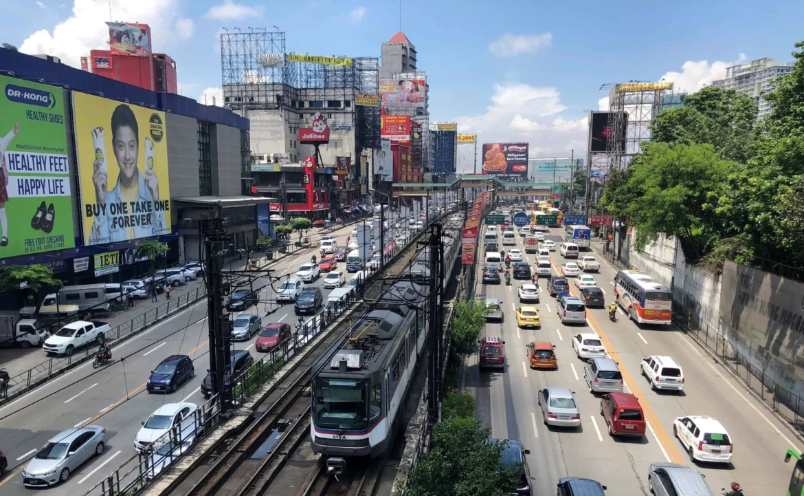 Busy Manila street with cars, jeepneys, and pedestrians during rush hour, showing the fast-paced city life.
