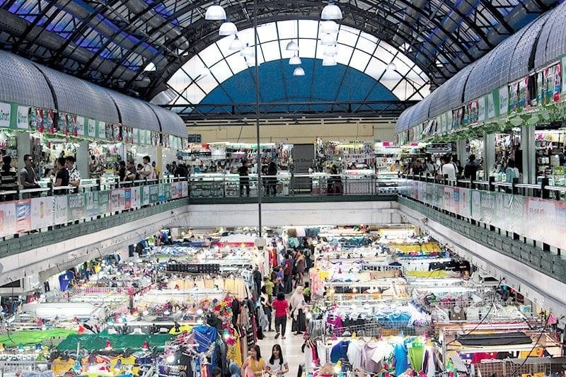 Greenhills Shopping Center bustling with shoppers, street stalls, and storefronts in Metro Manila.