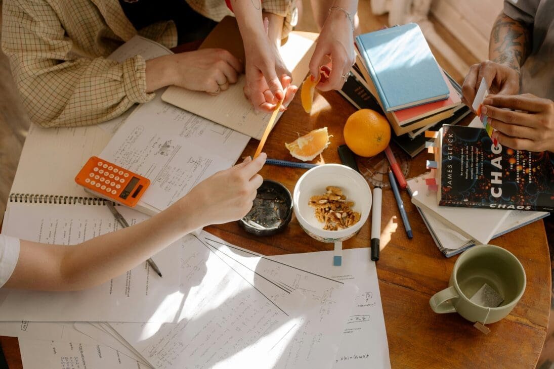 Friends reviewing expenses and planning a budget together during a trip.