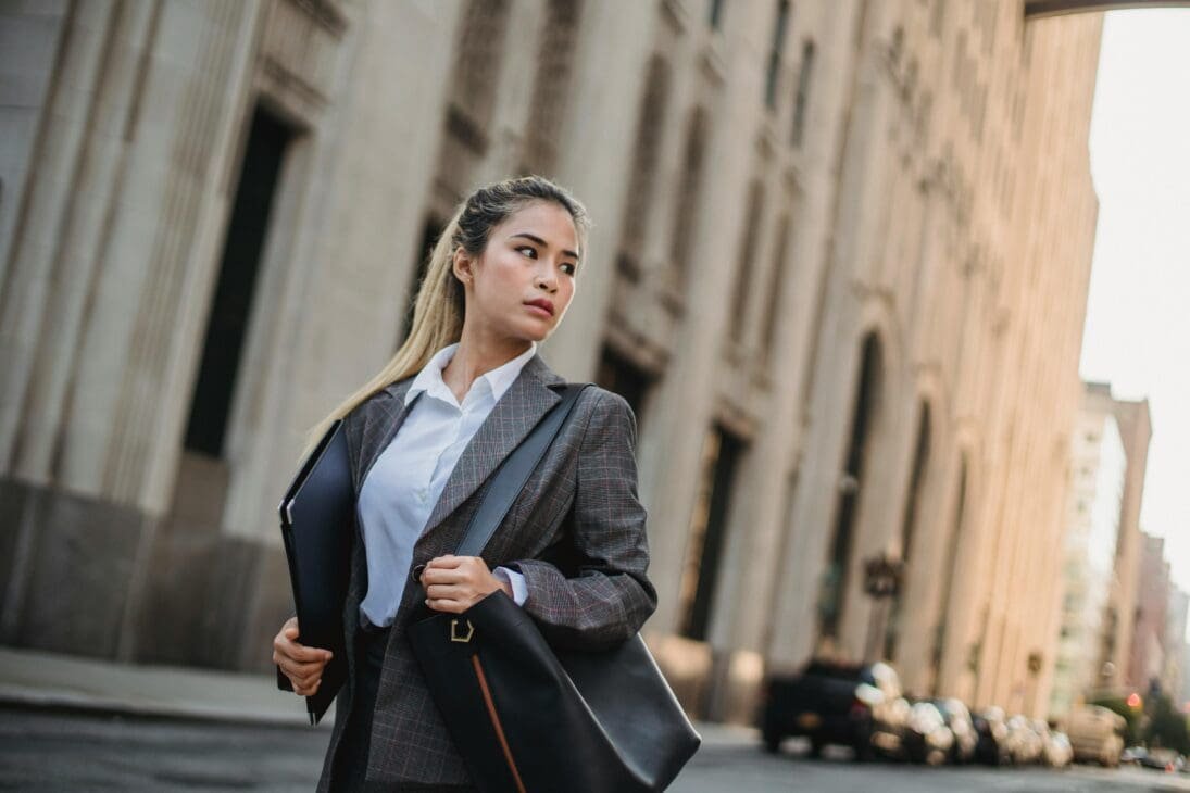 Young professionals in office attire walking along busy Manila streets, illustrating career-driven energy and provincial migration to the capital.