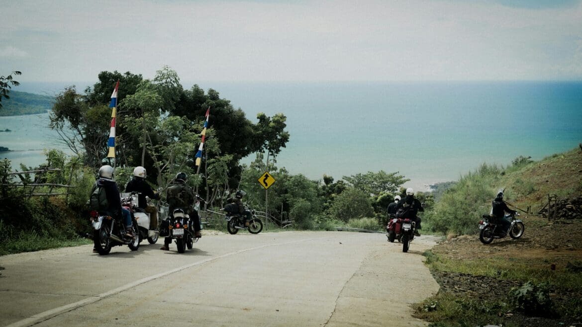 Friends riding motorcycles along a coastal road in Mindoro, enjoying wind and open space.