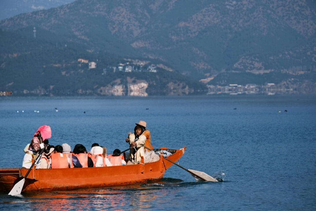 Life jackets hanging on a boat with a calm Lake Victoria backdrop, ready for passengers.