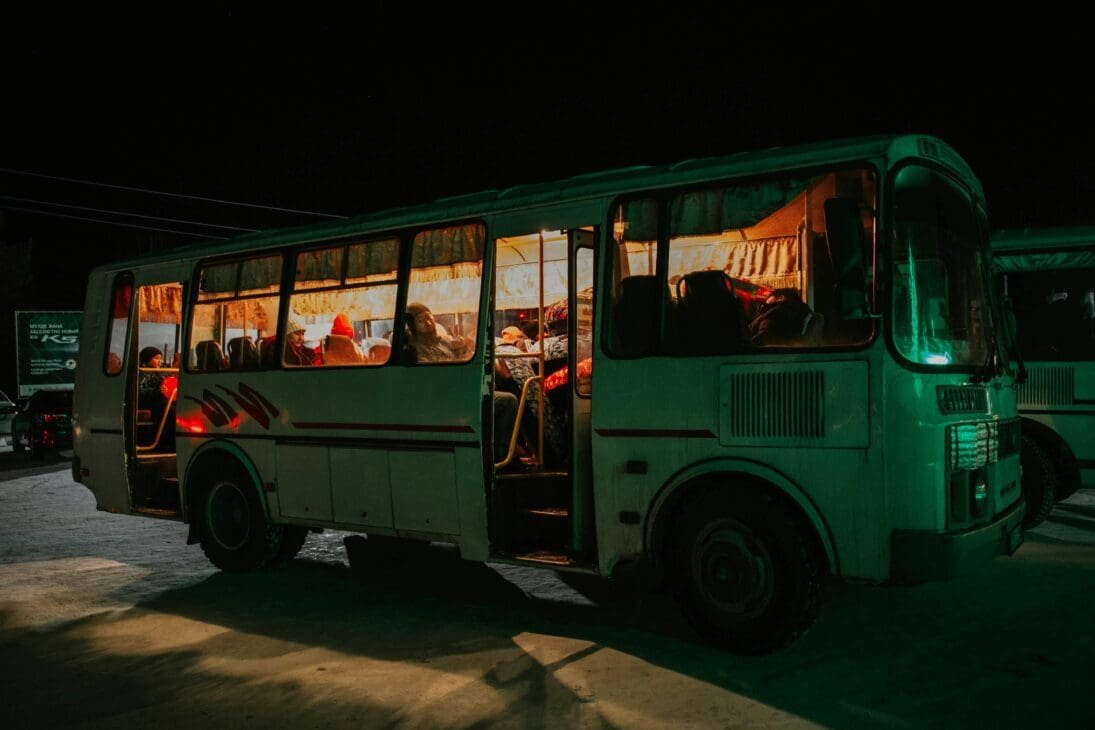 Dimly-lit bus at 1 AM with passengers resting quietly after Aurora Festival in Clark, Pampanga.